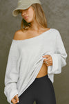Front view of model posing in the oversized pearl grey french terry Slouchy Pullover Sweatshirt with a wide, off-the-shoulder neckline and a JOAH BROWN logo patch on the right sleeve