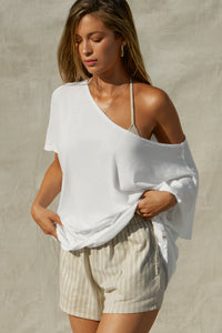 Front view of model posing in the oversized optic white classic cotton Slouchy Tunic Tee with a wide scoop neckline that can be worn off the shoulder