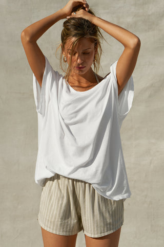 Front view of model posing in the oversized optic white classic cotton Slouchy Tunic Tee with a wide scoop neckline that can be worn off the shoulder