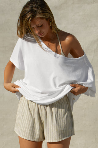 Front view of model posing in the oversized optic white classic cotton Slouchy Tunic Tee with a wide scoop neckline that can be worn off the shoulder