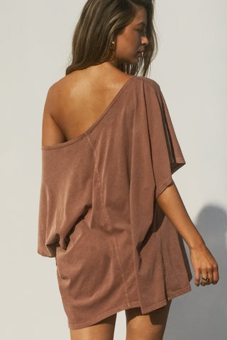 Back view of model posing in the oversized tobacco classic cotton Slouchy Tunic Tee with a wide scoop neckline that can be worn off the shoulder