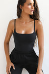 Front view of model posing in the soft and stretchy sueded onyx Smoothing Cami with a scoop neckline and thin straps