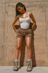 Full Body view of model posing in the soft and stretchy sueded yuma Smoothing Cami with a scoop neckline and thin straps with shorts and hiking boots