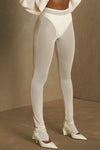 Front view of model from the waist down posing in the sheer high-waisted porcelain mesh Split Hem Legging with gathered ankles, exposed seams and button closures at the leg opening