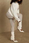 Side view of model posing in the sheer high-waisted porcelain mesh Split Hem Legging with gathered ankles, exposed seams and button closures at the leg opening