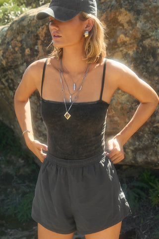 Front view of model posing outside in the semi-fitted charcoal washed rib Square Neck Cami with thin, wide-set straps and a clean, straight neckline.