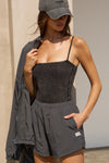Front view of model posing in the semi-fitted charcoal washed rib Square Neck Cami with thin, wide-set straps and a clean, straight neckline.