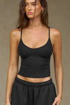 Front view of model posing in the fitted and slightly cropped black flexrib Strappy Scoop Tank with a scoop neckline and adjustable straps. 