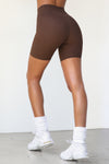 Back view of model from the waist down wearing the soft stretchy high-waisted sueded umber Biker Short with a wide waistband