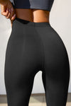 Close up detail back view of model from the waist down wearing the sleek and stretchy full length sueded onyx The Body Legging with a mid-rise elastic waistband