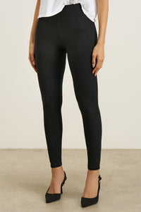 Front view of model from the waist down posing in the sleek and stretchy full length sueded onyx The Body Legging with a mid-rise elastic waistband