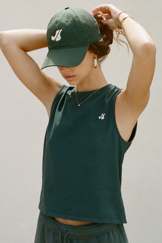 Front view of model posing in the structured six-panel  alpine The Classic Cap with a curved brim, adjustable back strap and an embroidered front and back Joah Brown logo