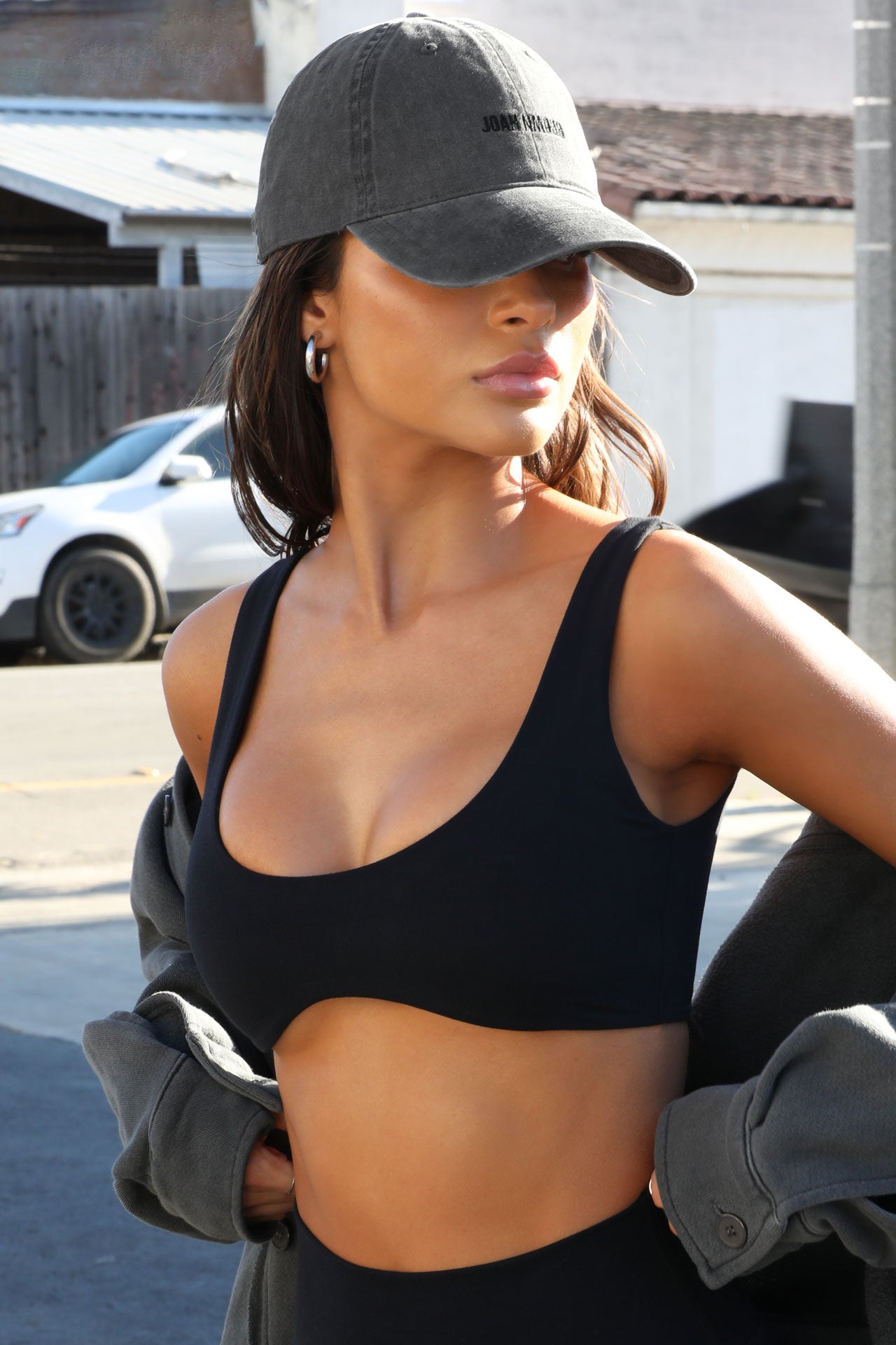 Side view of model wearing the six-panel washed black Official Cap with a curved brim and an embroidered upside down Joah Brown logo on the front