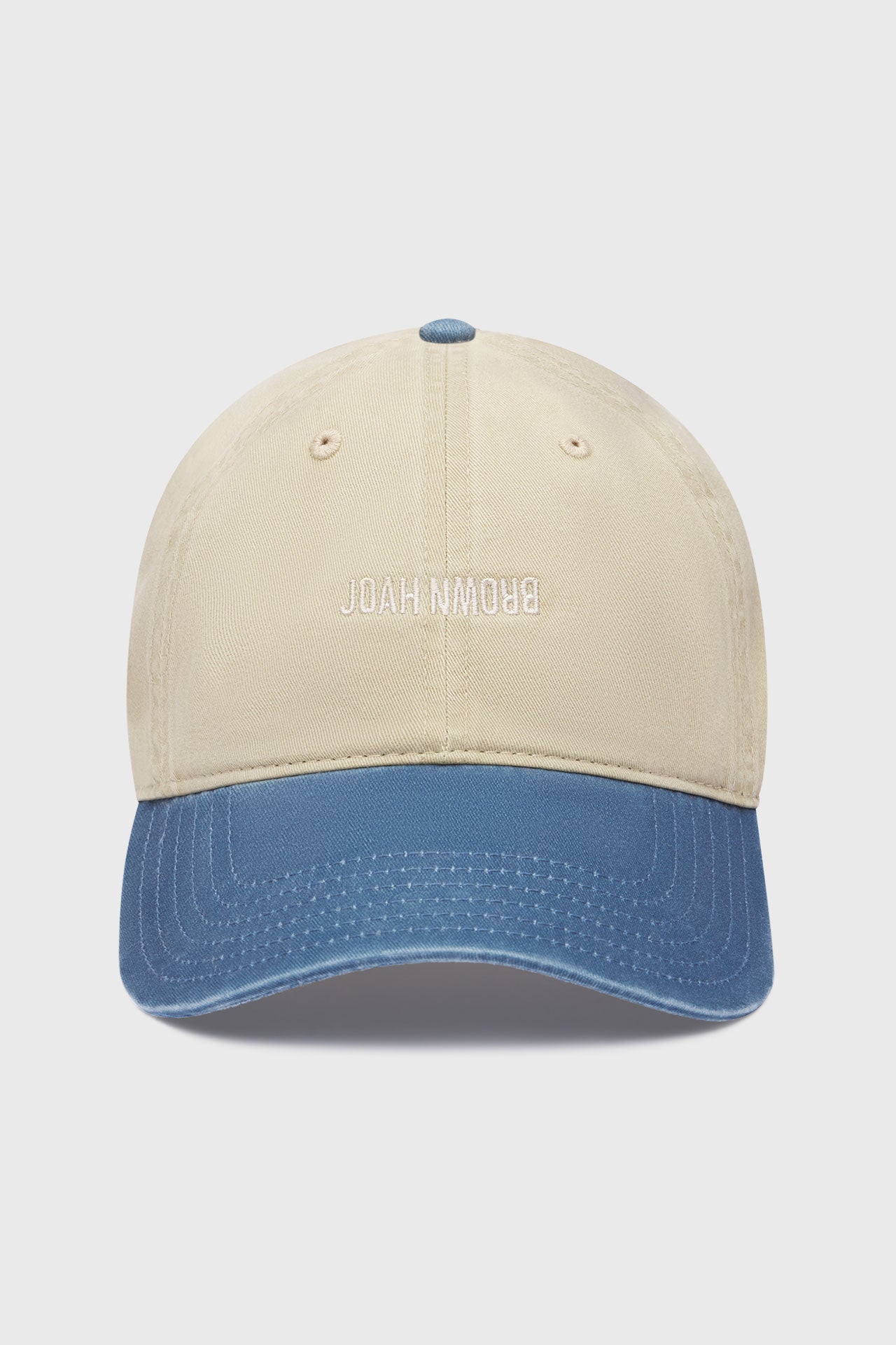 Front flat lay view of the six-panel khaki with vintage blue brim Official Cap with a curved brim and an embroidered upside down Joah Brown logo on the front