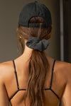 Back view of model wearing the six-panel black Signature Cap with a curved brim and adjustable strap