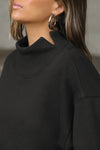 Close up detail side view of model posing in the comfortable black french terry Turtleneck Sweatshirt pullover with a side split in the collar and a slightly oversized fit