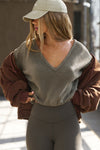 Front view of model posing in the slouchy oakmoss sherpa V Neck Pullover sweatshirt with a wide V-neckline that can be worn on or off the shoulders.