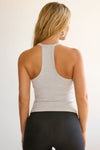 Back view of model wearing the v neck racerback tank in pearl flexrib with the second skin in sueded onyx