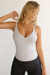 Front view of model wearing the v neck racerback tank in pearl flexrib with the second skin legging in sueded onyx