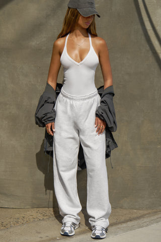 Full body front view of model posing in the fitted stretchy white flexrib V Neck Racerback Tank with a deep v neckline and thin straps