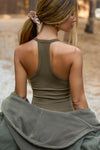 Back view of model posing outside in the fitted stretchy woodland flexrib V Neck Racerback Tank with a narrow racerback silhouette and thin straps