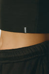 Close up detail side view of the fitted stretchy cropped black flexrib Varsity Tank Bra with a scoop neckline