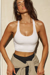 Front view of model posing in the fitted stretchy cropped white flexrib Varsity Tank Bra with a scoop neckline