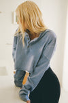Front view of model posing in the cropped, loose-fitting denim cotton Vintage Henley Long Sleeve top with dropped shoulders and custom JOAH BROWN buttons