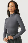 Side view of model posing in the form fitting stretchy smoke rib Classic Turtleneck long sleeve top