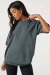 Front view of model posing in the relaxed fit evergreen cotton Oversized Crew Tee with a crew neckline and joah brown logo patch on the upper left side