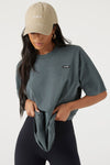 Front view of model posing in the relaxed fit evergreen cotton Oversized Crew Tee with a crew neckline and joah brown logo patch on the upper left side
