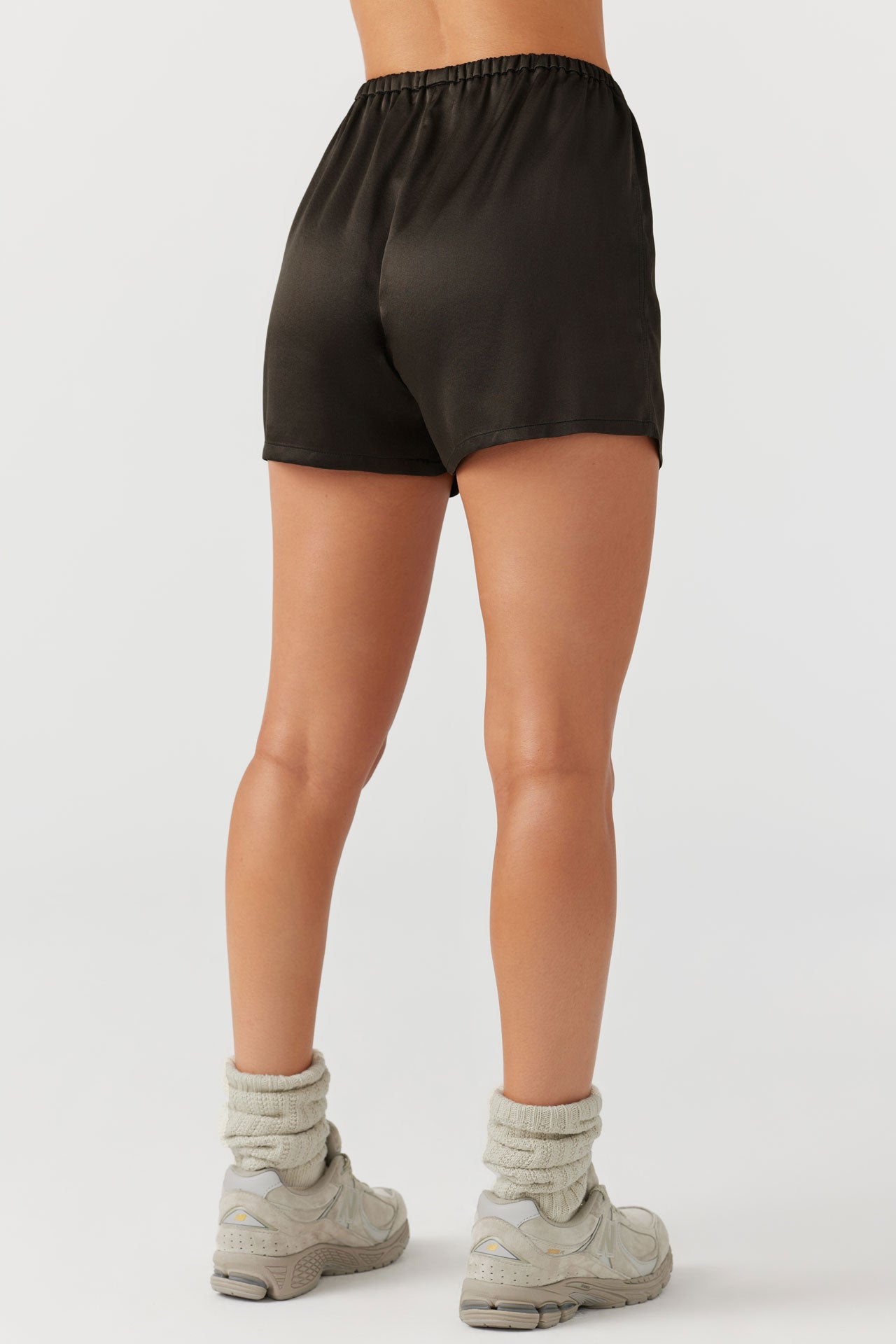 Back view of model from the waist down posing in the comfortable, boxer-style espresso Relaxed Silk Short with an elastic waistband