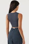 Back view of model posing in the fitted and cropped contouring sueded navy Second Skin Tank with a high crew neckline