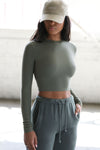 Front view of model posing in the fitted cropped summit rib Cropped Crew Long Sleeve top with a crew neckline