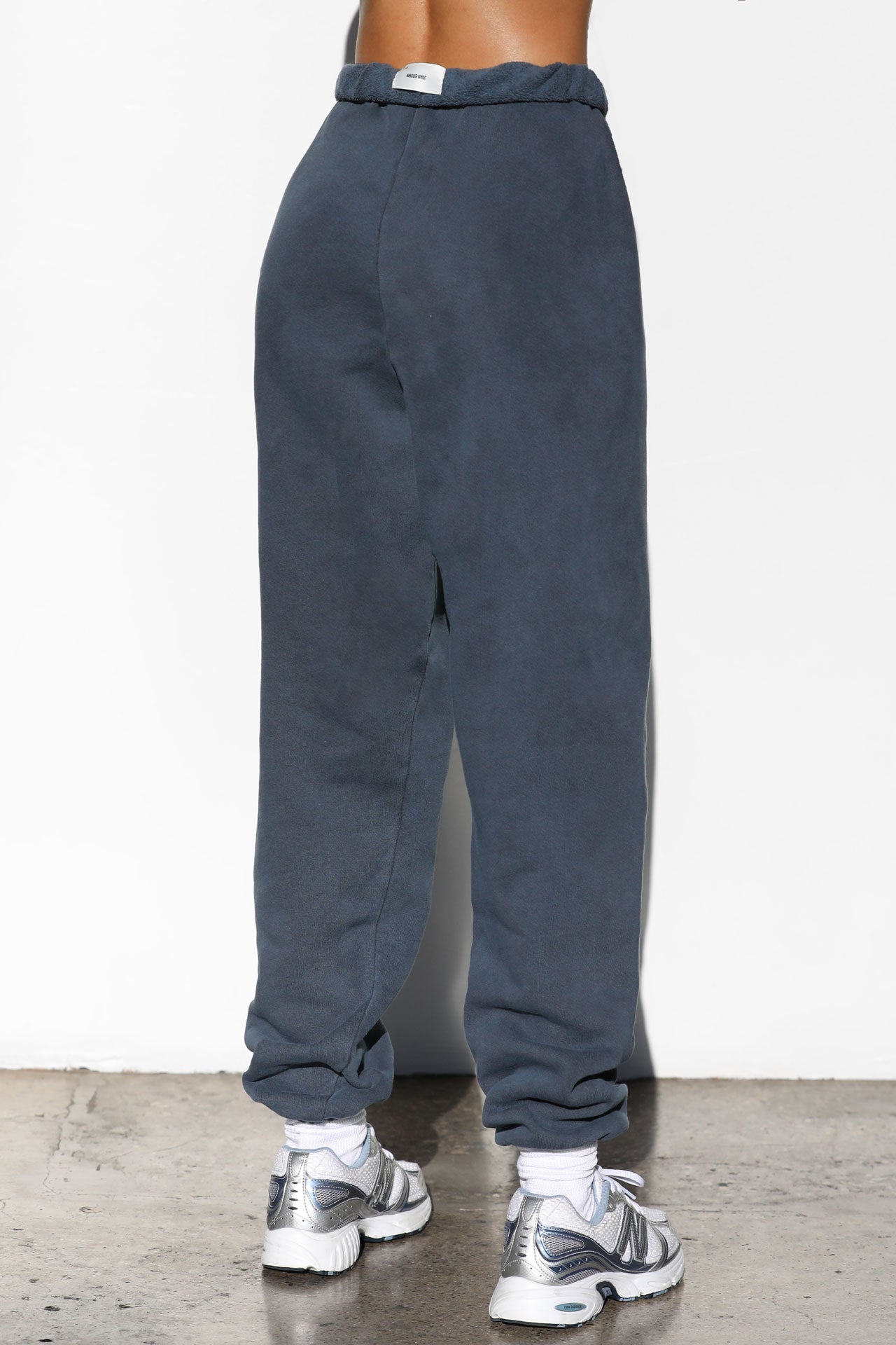 Back view of model from the waist down wearing the oversized loose fit washed navy french terry Oversized Jogger with an elastic waistband and ankle cuffs