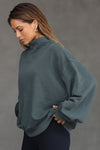Side view of model wearing the comfortable evergreen french terry Turtleneck Sweatshirt pullover with a side split in the collar and a slightly oversized fit