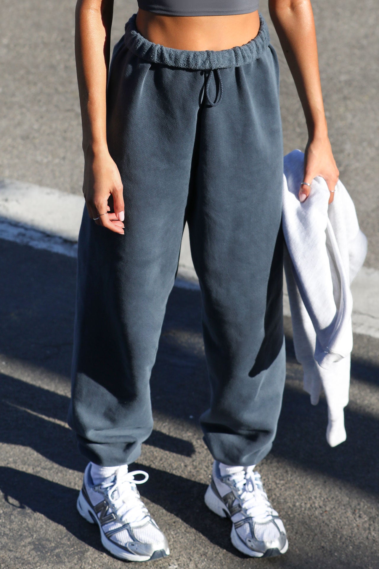 Front view of model from the waist down wearing the oversized loose fit washed navy french terry Oversized Jogger with an elastic waistband and ankle cuffs