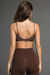 Back view of model posing in the lightweight tobacco modal Minimal Bra top with thin adjustable elastic straps and stitch detailing