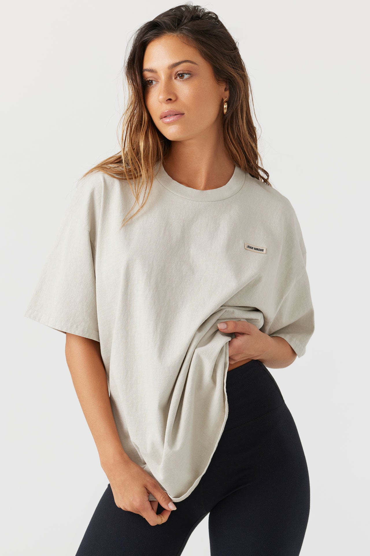 Front view of model posing in the relaxed fit fog cotton Oversized Crew Tee with a crew neckline and joah brown logo patch on the upper left side