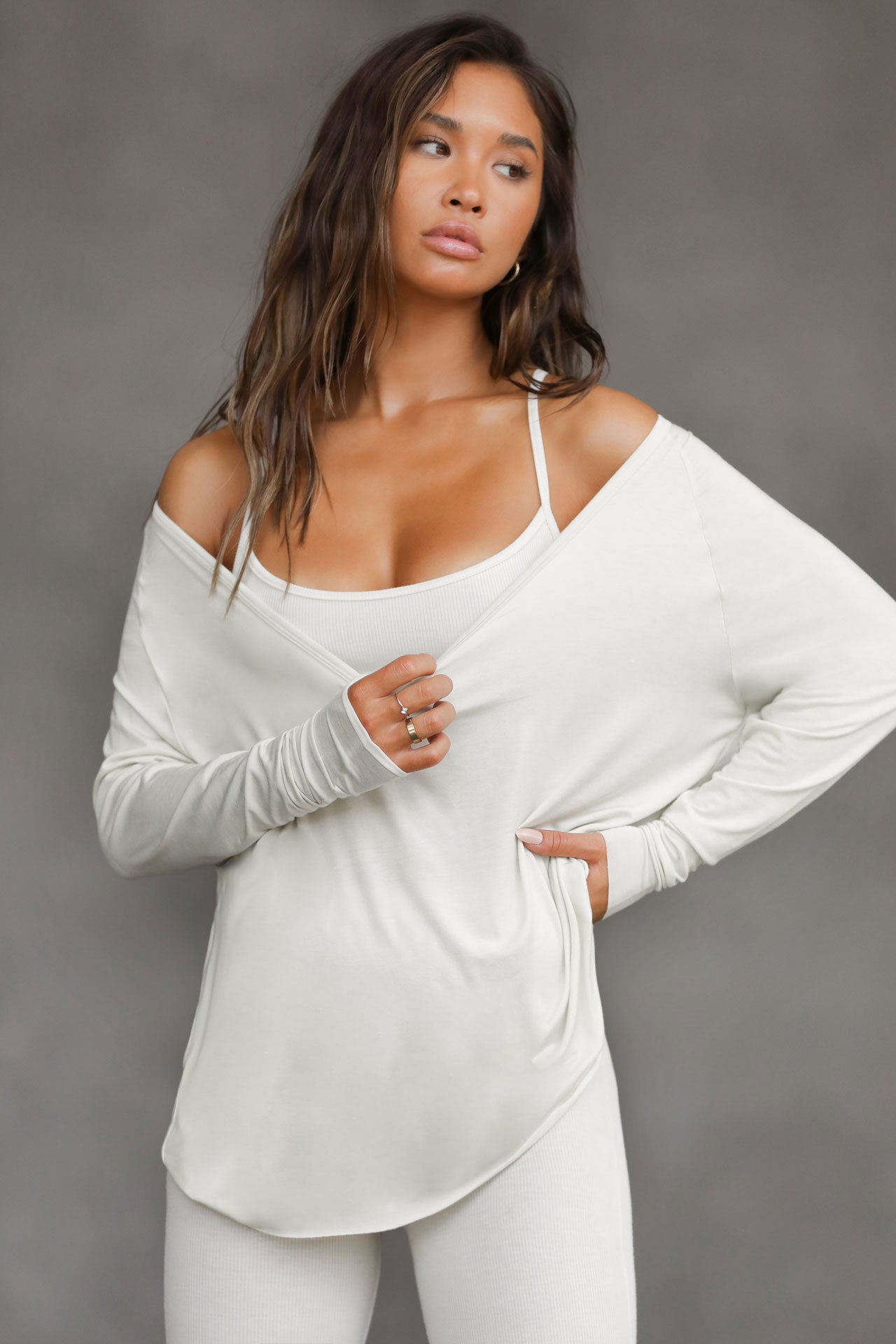 Front view of model posing in the soft relaxed fit chalk modal Relaxed V Neck Long Sleeve top with fitted sleeves and a wide v neckline that can be worn on or off the shoulders