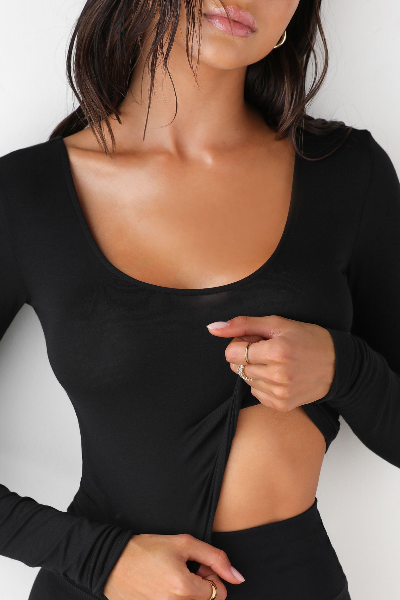 Close up front view of model wearing the fitted soft black modal Scoop Neck Long Sleeve top with a deep scoop neckline and fitted sleeves