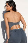 Back view of model posing in the ultra-cropped sueded navy Curve Scrunch Tank with delicate corded straps in a cross back design