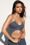 Side view of model posing in the ultra-cropped sueded navy Curve Scrunch Tank with delicate corded straps, ruched cups at the bust and a curved hem