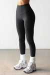 Front view of model from the waist down posing the full length and high-waisted sueded onyx Second Skin Legging with a wide, v-shaped waistband
