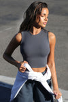 Front view of model posing in the fitted and cropped contouring sueded navy Second Skin Tank with a high crew neckline