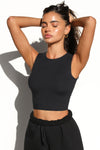 Front view of model posing in the fitted and cropped contouring sueded onyx Second Skin Tank with a high crew neckline