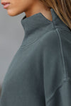 Close up detail side view of model wearing the comfortable evergreen french terry Turtleneck Sweatshirt pullover with a side split in the collar and a slightly oversized fit