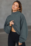 Front view of model wearing the comfortable evergreen french terry Turtleneck Sweatshirt pullover with a side split in the collar and a slightly oversized fit
